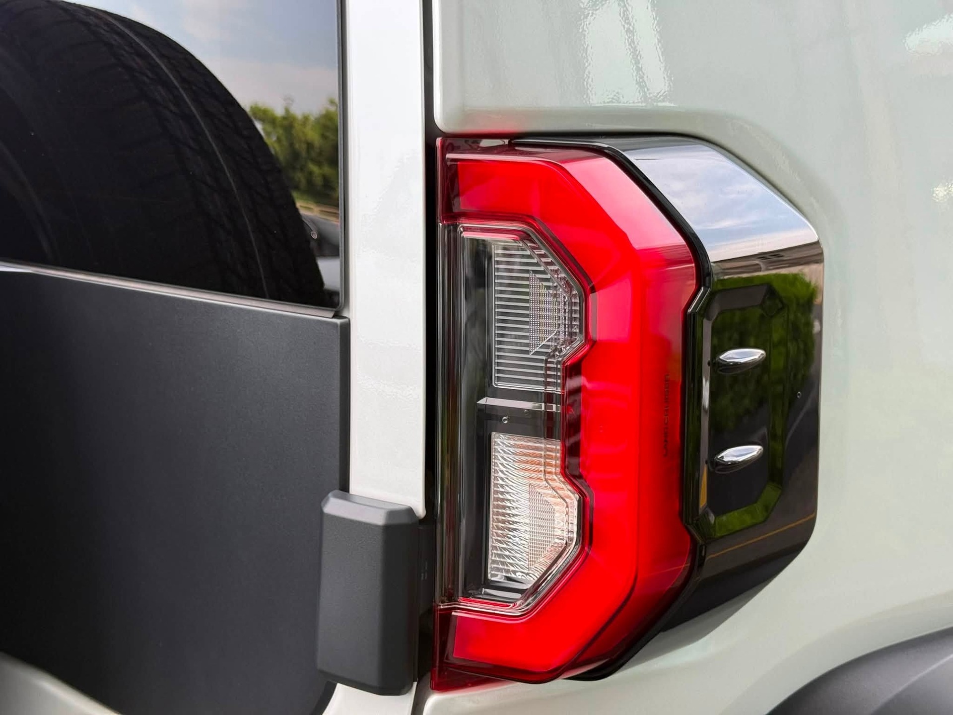 Cận cảnh chi tiết đèn hậu xe Toyota Land Cruiser FJ với các thấu kính LED sắc sảo, viền ngoài tối màu tạo vẻ đẹp nam tính đầy cuốn hút.
